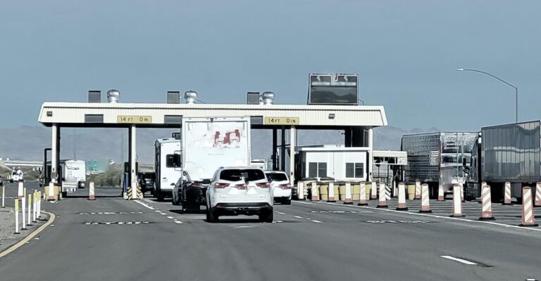 Cars and trucks line up to cross the border through a border crossing.