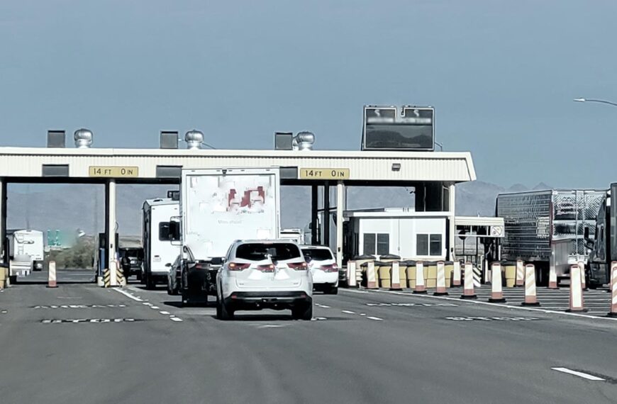 Cars and trucks line up to cross the border through a border crossing.