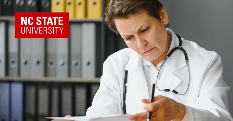 NC State University doctor and researcher sits reading at her desk.