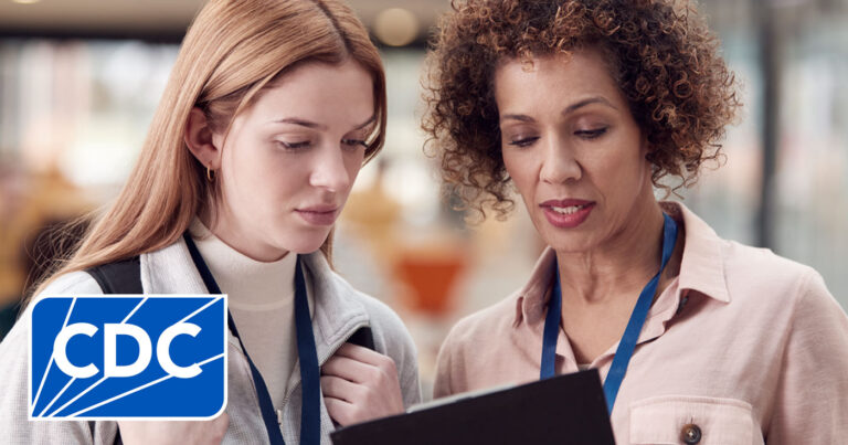 Two medical professionals meet in the hallway to look at the results of their research spanning many years.