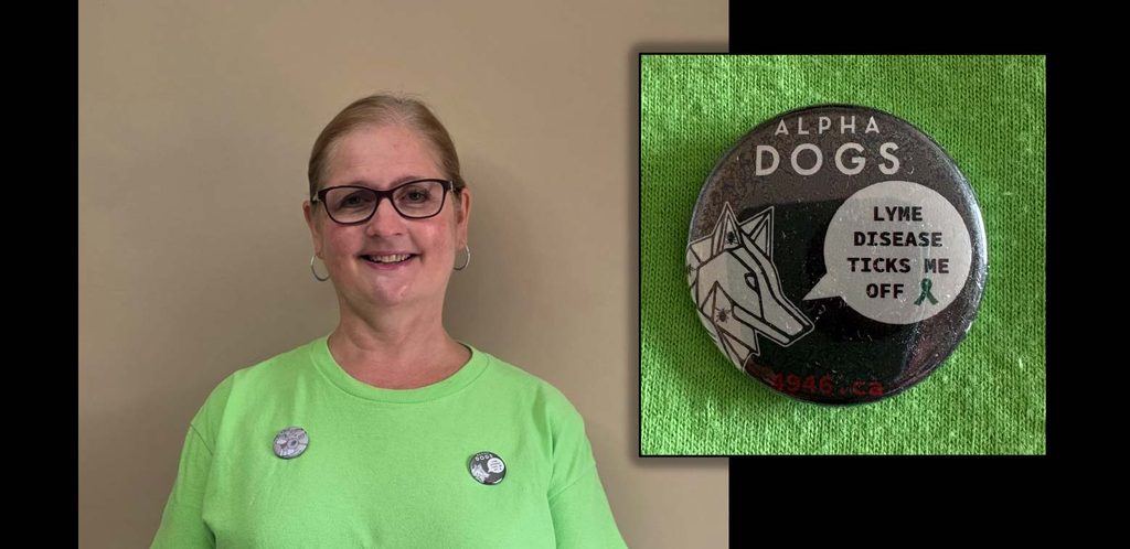 Kimberly Fosbury stands smiling wth her green shirt and a close up of her pin which says "Lyme disease ticks me off".