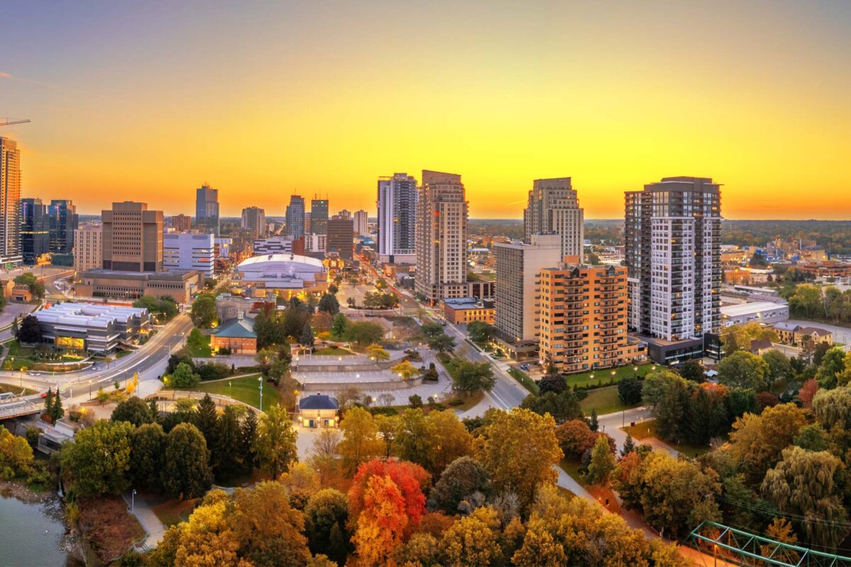 The sun sets over London Ontario in the autumn with vivid yellow and red glowing around the city scape.