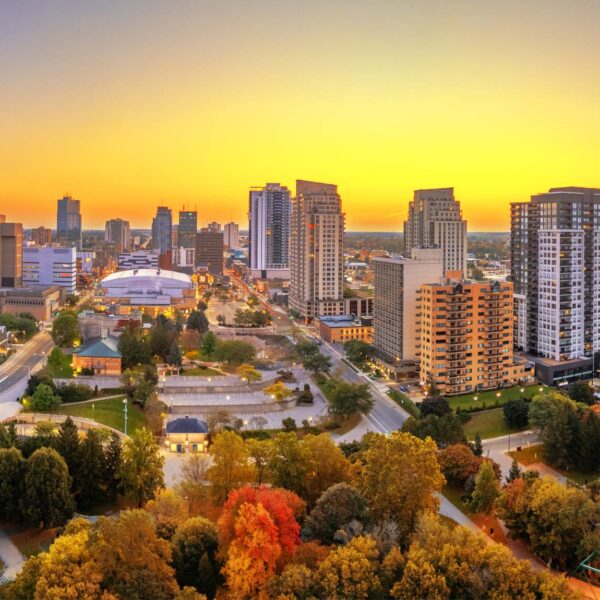 The sun sets over London Ontario in the autumn with vivid yellow and red glowing around the city scape.
